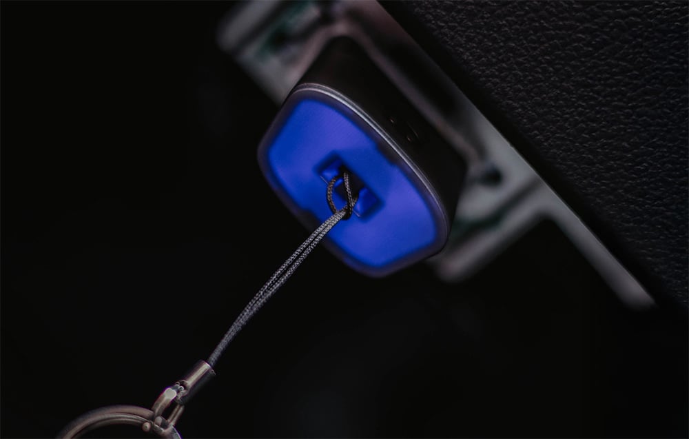 Close-up of OBD2 port with blue backlight and diagnostic cable connected