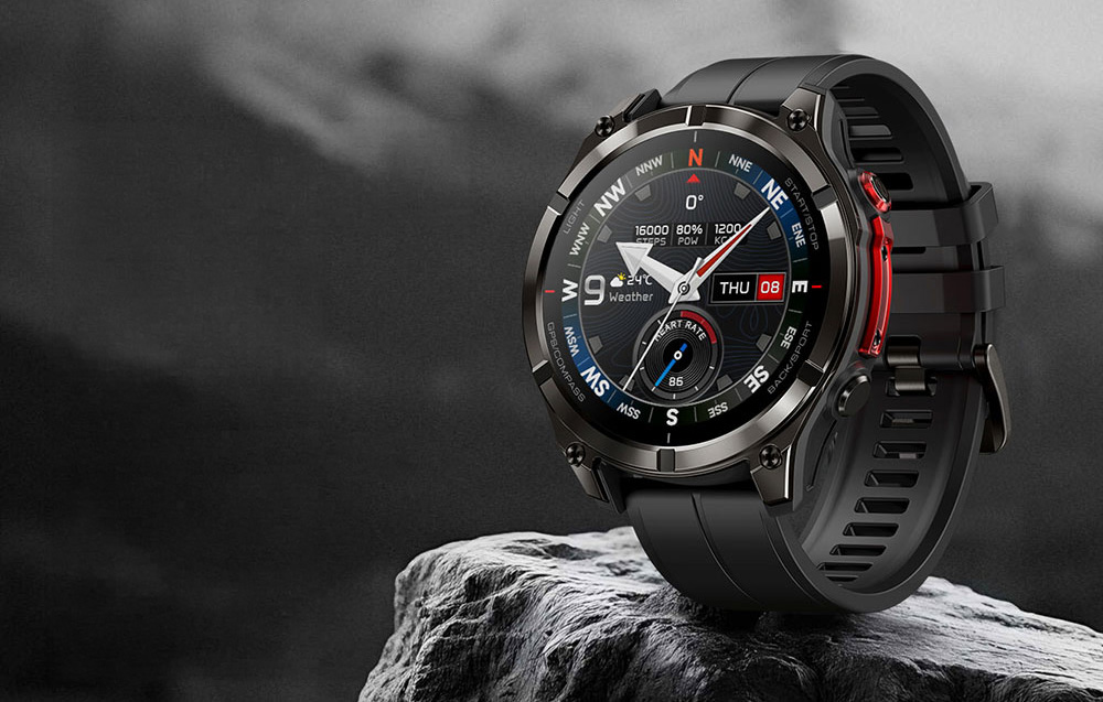 A black, durable sports smartwatch with a compass face placed on a rock