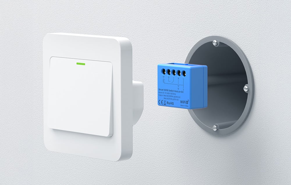 Smart switch module mounted in a flush-mounted box next to a light switch.