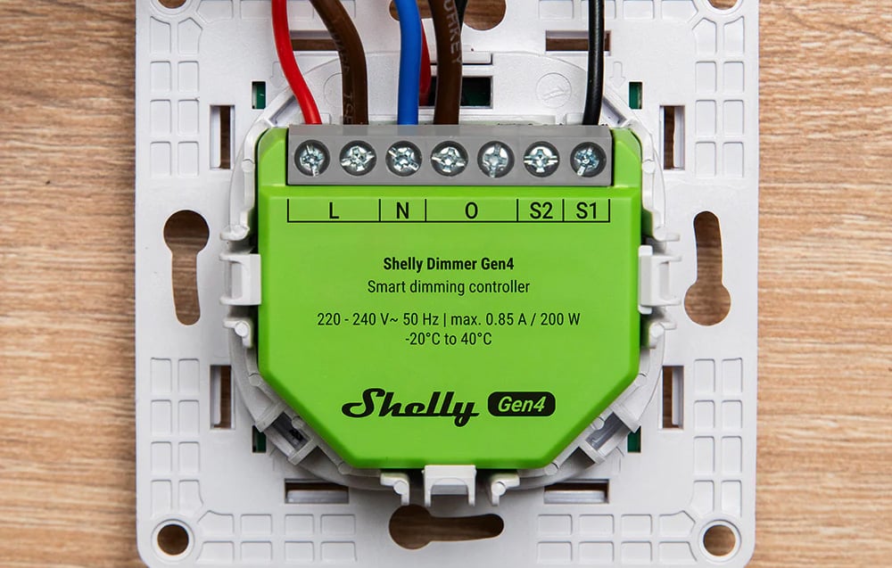 Close-up of the front panel of the green device with visible input markings and secured power cables.