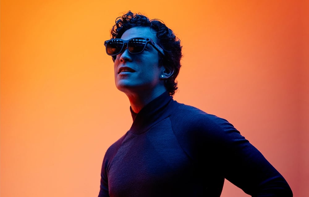 Man with XR glasses on orange background