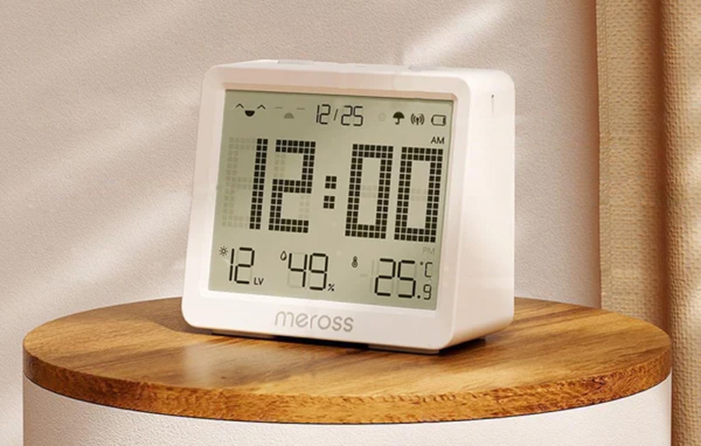 Meross clock with large digital display, showing time, temperature and humidity, set on a round table