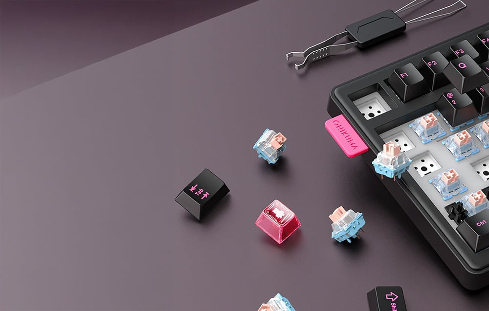 Black Onikuma keyboard with removed keys and switch replacement tool on dark background