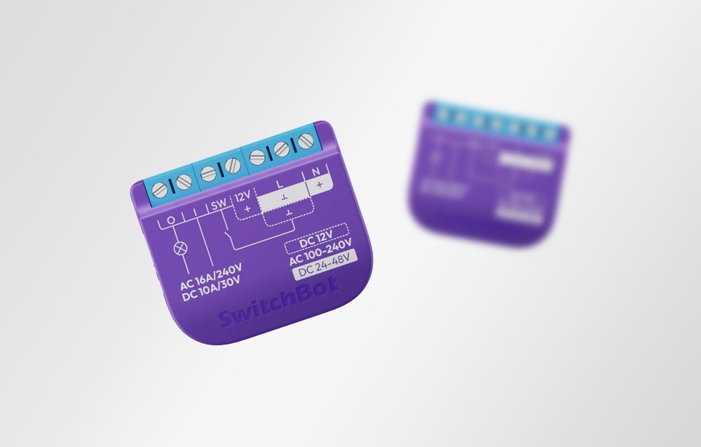 Two SwitchBot modules in purple with blue terminals, shown front and back against a white background