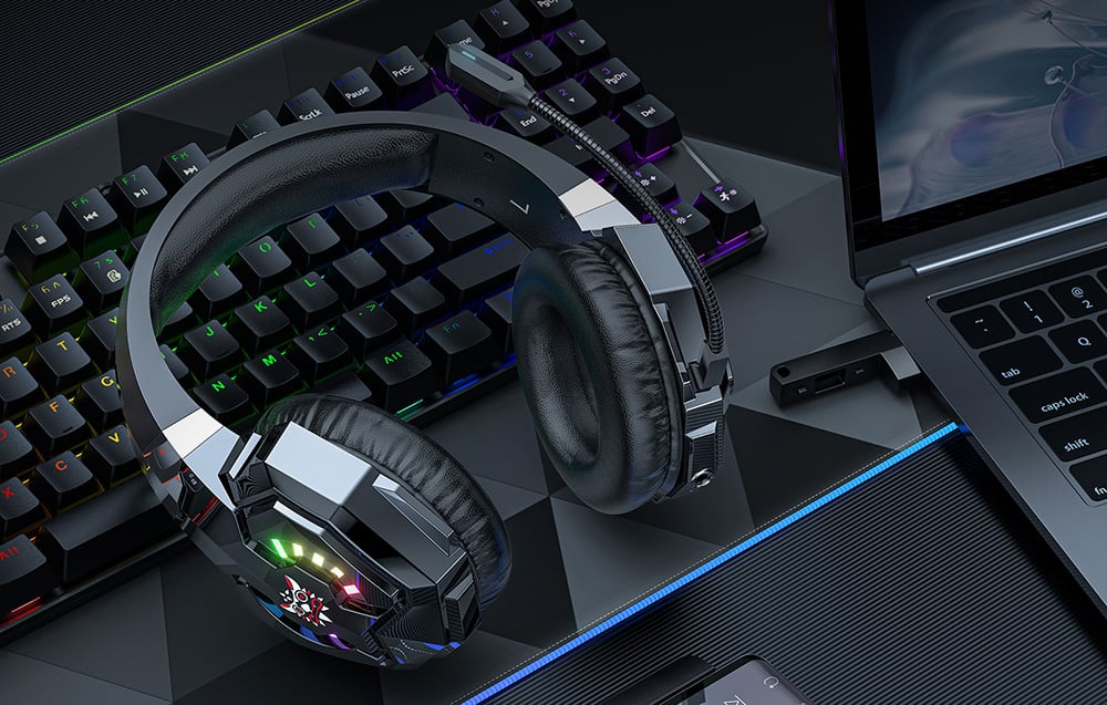 Onikuma headphones lying on the keyboard, next to it is a laptop