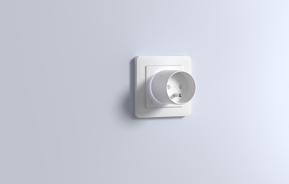 A smart plug connected to a wall outlet on a light background.