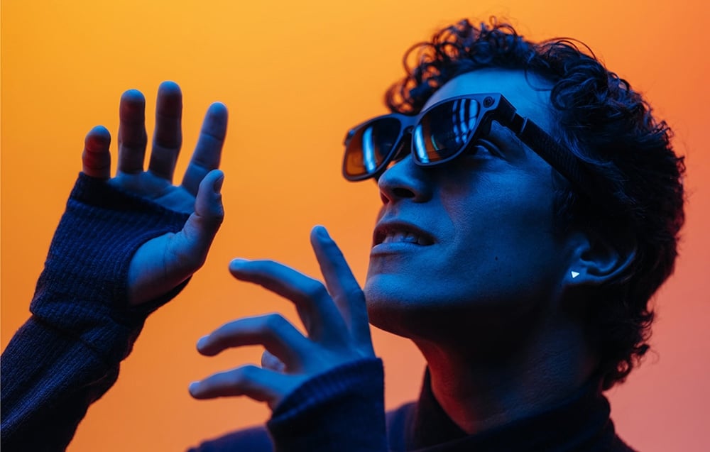 Person using XR glasses against an orange background