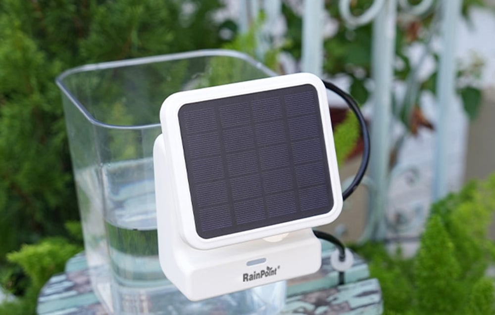 RainPoint solar panel standing next to a water container on a balcony or in the garden