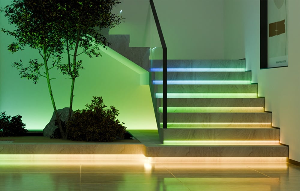 Stairs lit by LED strip in orange, green, and blue