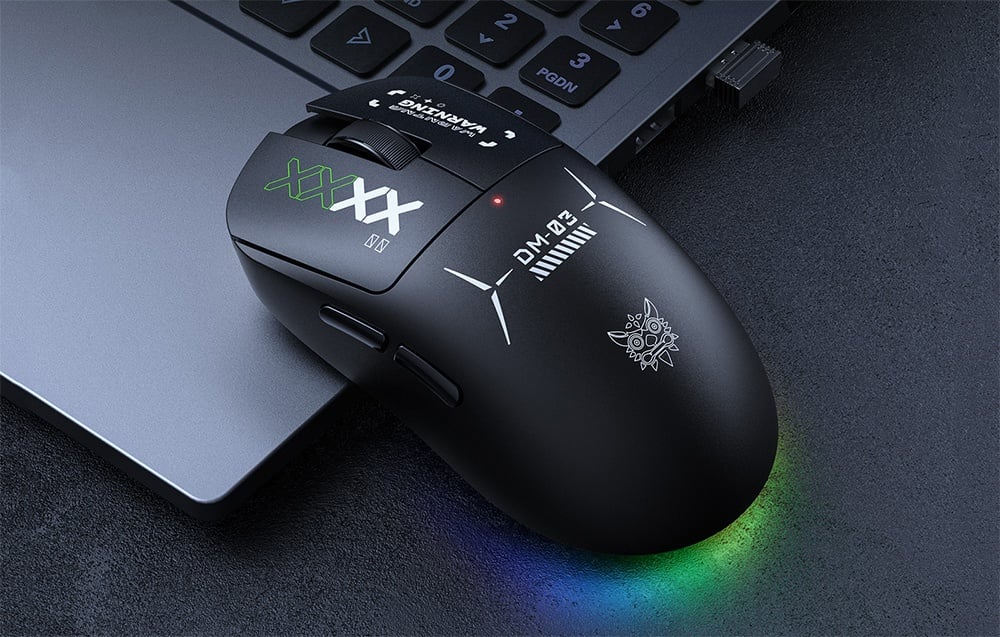 Black Onikuma computer mouse resting next to a laptop