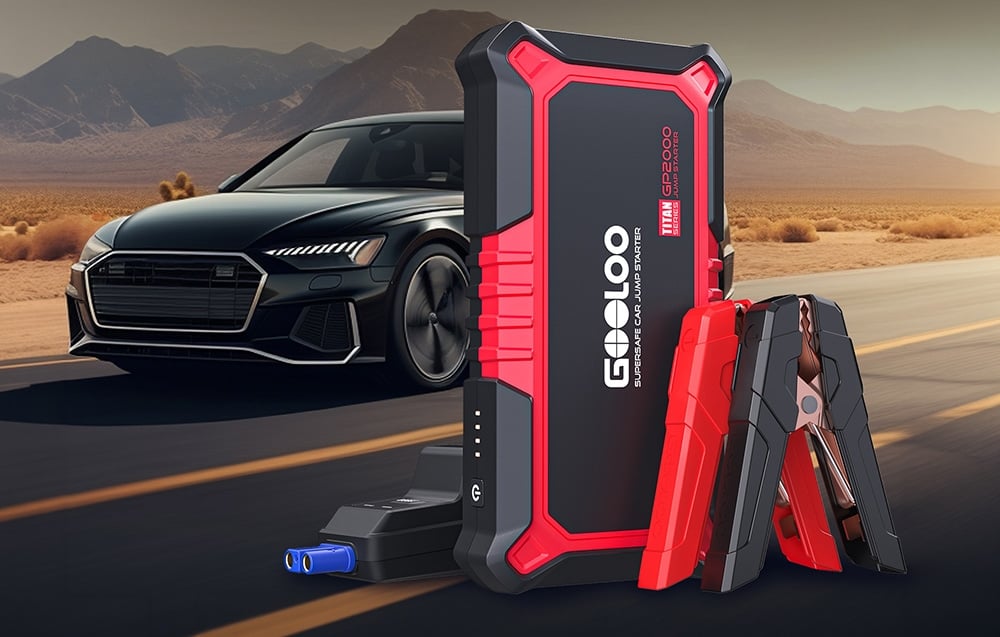 Car jump starter positioned on the road next to a car in the background