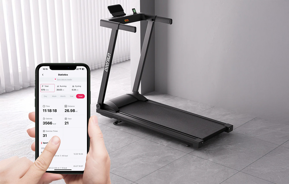 DeerRun treadmill next to a hand holding a smartphone with an app showing workout statistics