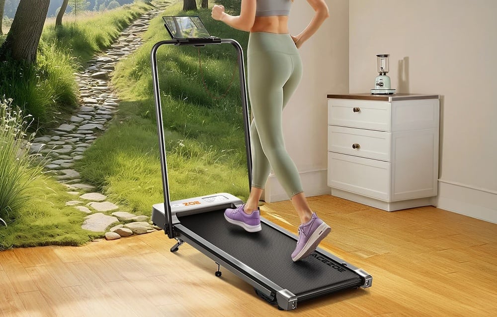 A woman in a green tracksuit on a treadmill in a bright room, with a forest landscape in the background