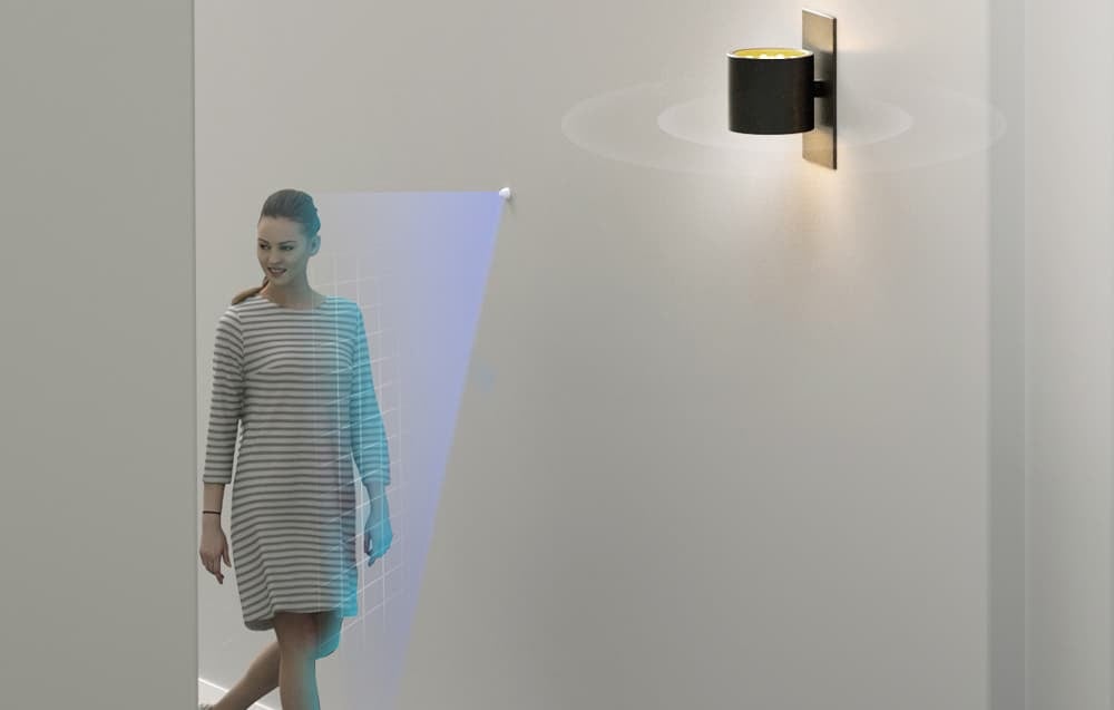 A woman walks down the hallway; the lamp turns on when motion is detected