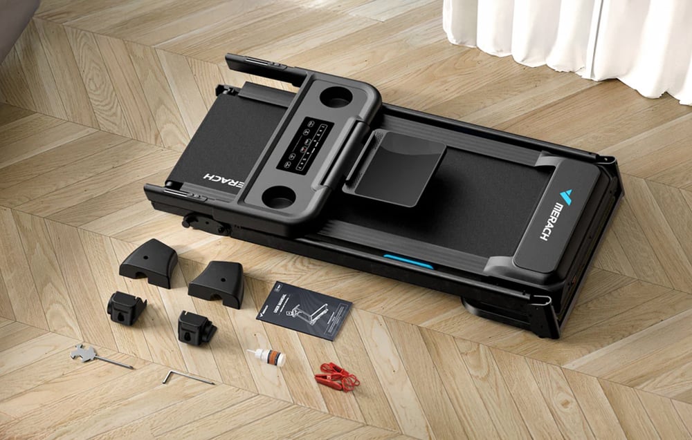 Merach treadmill folded with visible assembly parts and instructions