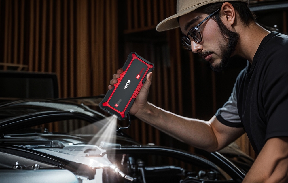 A person using the car jump starter as a flashlight with the engine running