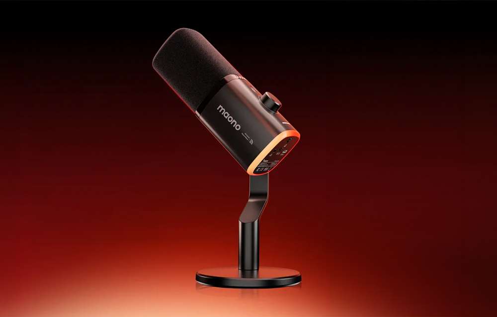 Black Maono wireless microphone mounted on a desk stand, illuminated in orange