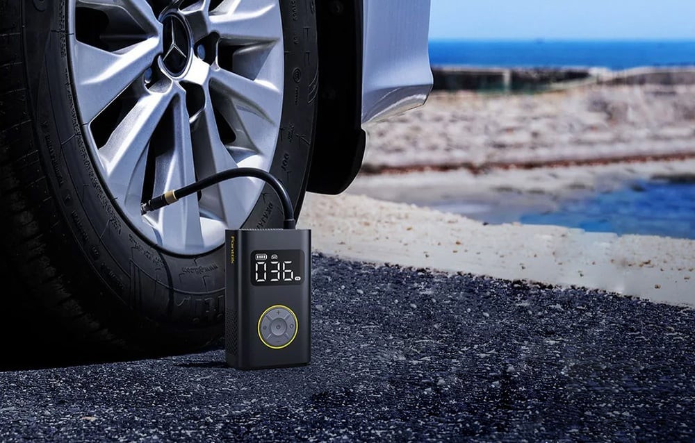 Portable compressor with display stands on the ground and inflates the tire of the car.