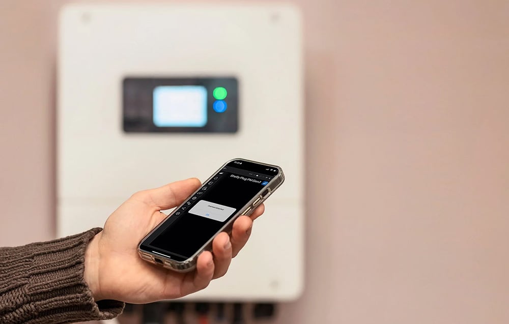 A network overload notification displayed in the Shelly Plug PM Gen3 mobile app held in front of an inverter.