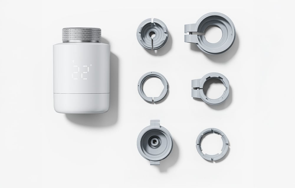 Thermostat with interchangeable adapters for radiators on a white background