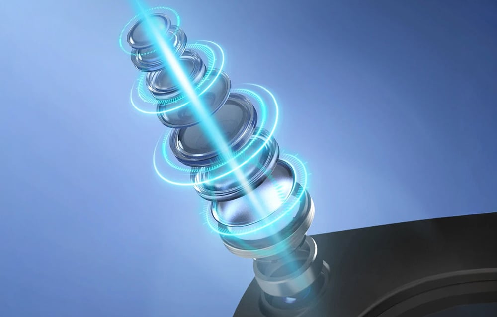 Technological cross-section of a camera lens with a blue beam of light passing through the optical layers.