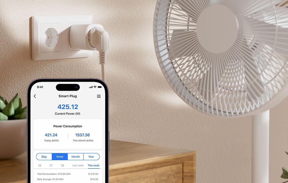 Smartphone displaying an app for monitoring the energy consumption of a smart plug connected to a fan standing on a wooden chest of drawers