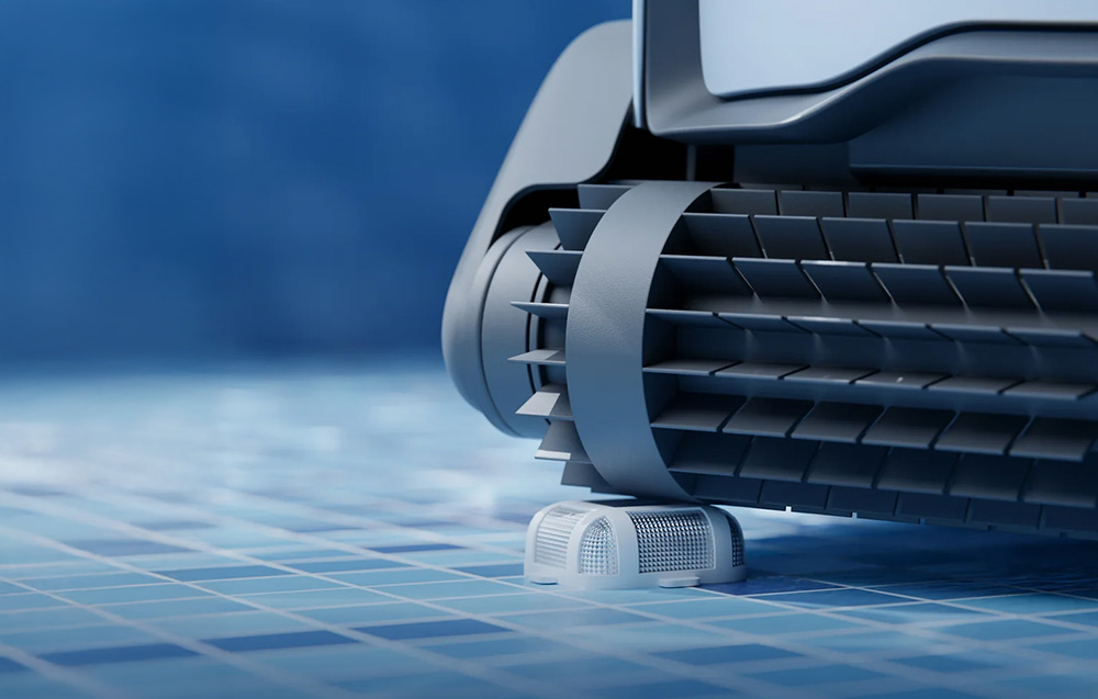 Close-up of a pool robot’s track with a visible cleaning brush moving across blue tiles