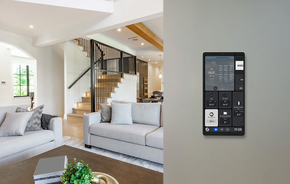 The silver Shelly control panel installed in the living room, displaying detailed tiles showing the status of smart home devices.