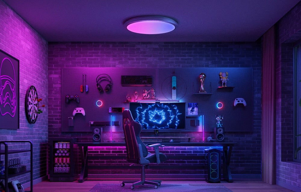 Gaming desk with monitor and accessories illuminated with purple light, Yeelight Vega night light mounted on the wall.