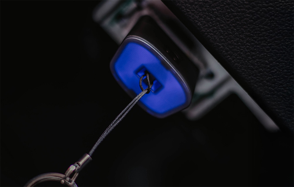 Close-up of OBD2 port with blue backlight and diagnostic cable connected