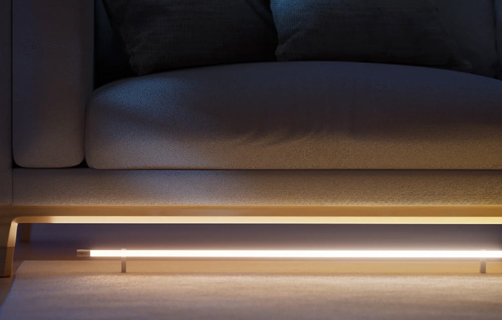 LED strip under the sofa illuminating the floor with warm yellow light - decorative lighting