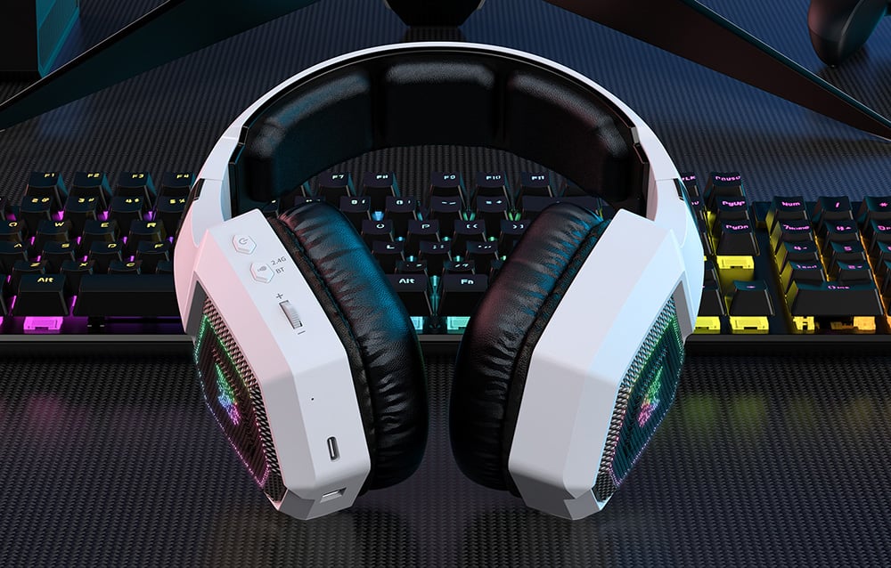 White gaming headphones lying on an illuminated keyboard