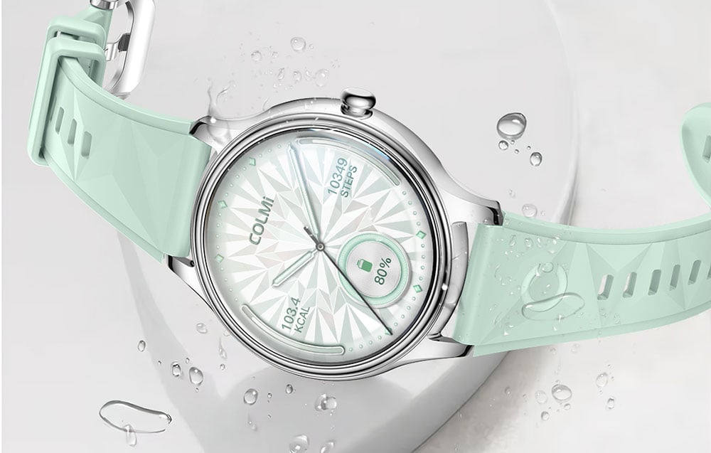 Silver COLMI smartwatch with a mint strap with a geometric pattern, displaying the number of steps and battery level on the dial against a water drop background