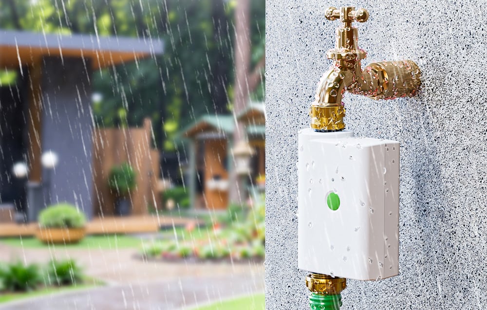 Smart irrigation controller mounted on a building wall during a downpour