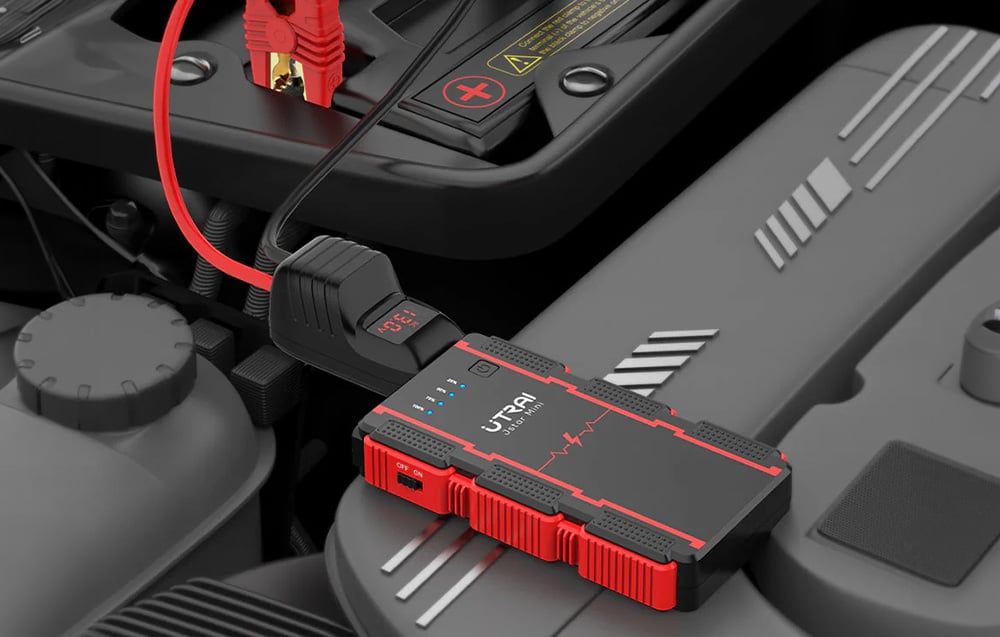 The jump starter is connected via the red clamp to the car battery under the hood.
