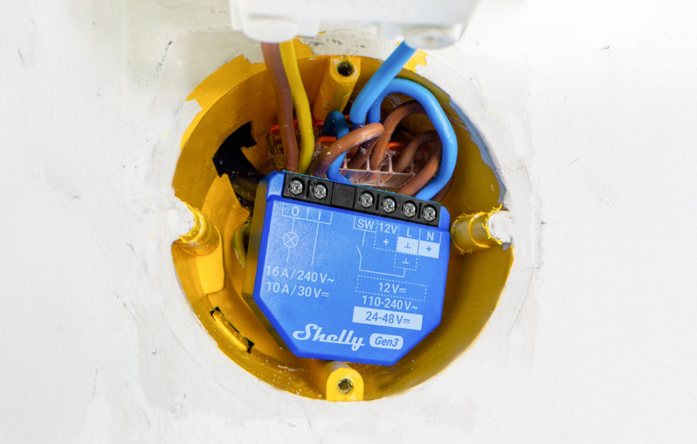 Shelly Gen3 module mounted in an electrical box with wires plugged in, embedded in the wall