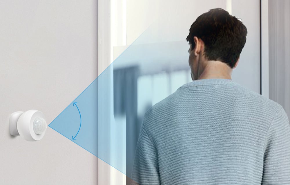 Motion sensor on the wall with visualization of the angle of detection directed at a person entering the room