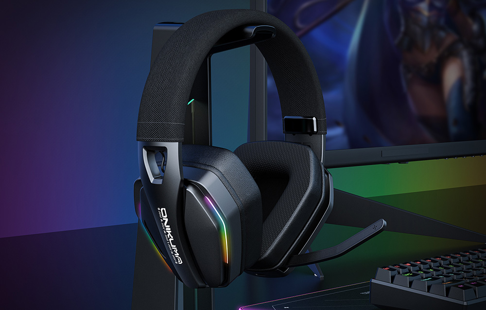 Onikuma gaming headphones hanging on a bracket next to a keyboard and monitor