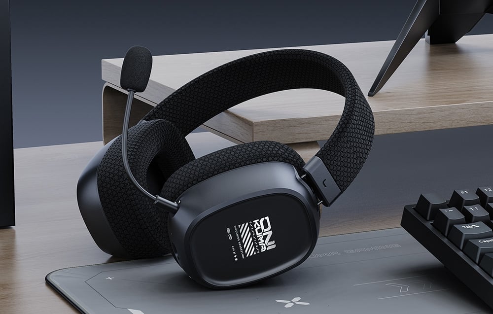 Gaming headphones with microphone lying on a mouse pad on a wooden desk