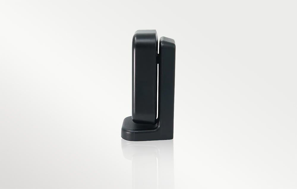 A presence sensor in a black housing with a visible mounting bracket, side view.