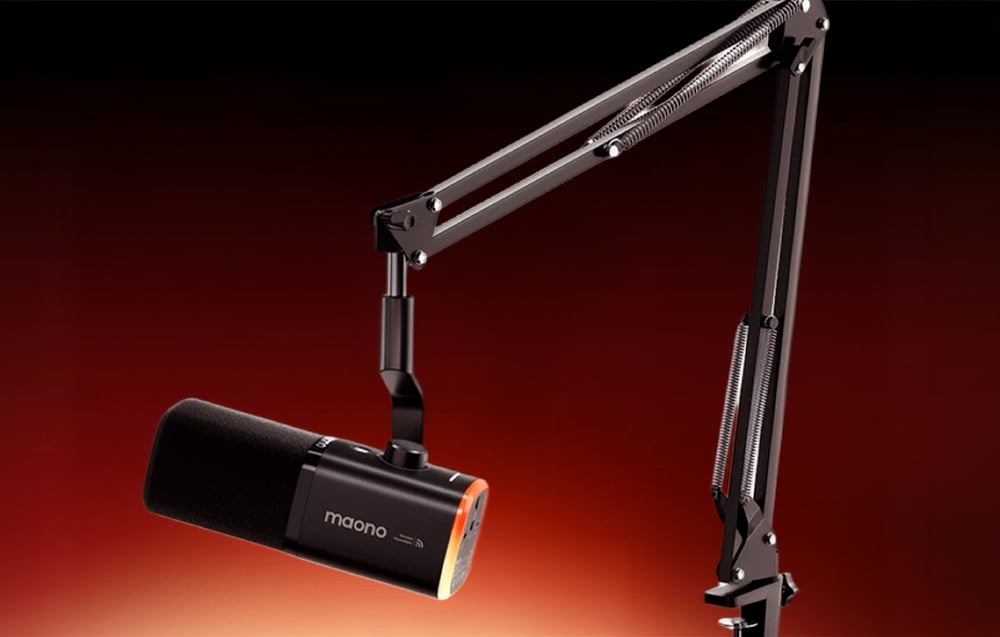 A black Maono microphone mounted on an adjustable, spring-loaded metal desk arm