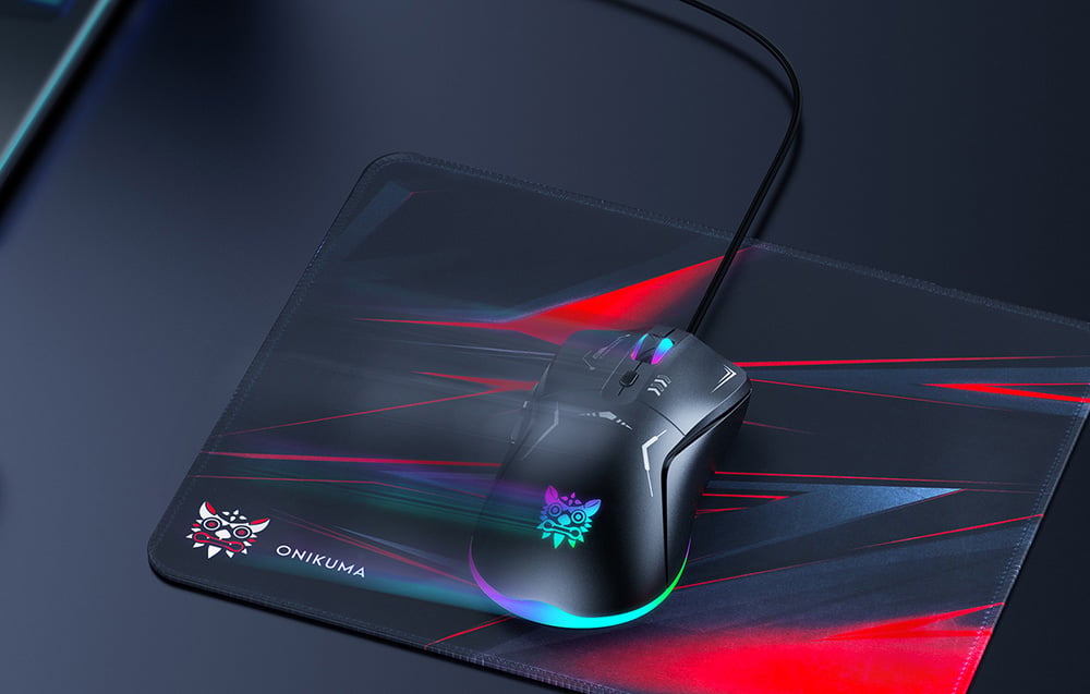 Onikuma mouse with colorful backlighting on a black-and-red mouse pad lies on a black desk