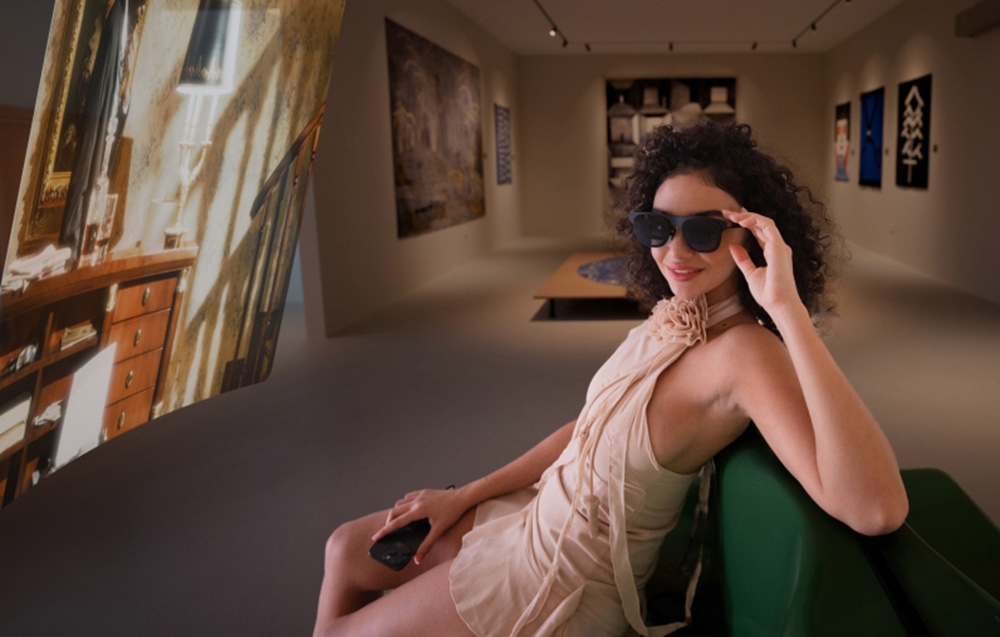 smiling woman wearing AR glasses watching a movie in a beige room