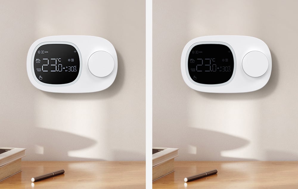 2 thermostats pressed against the wall, one with the display on and one with the display off