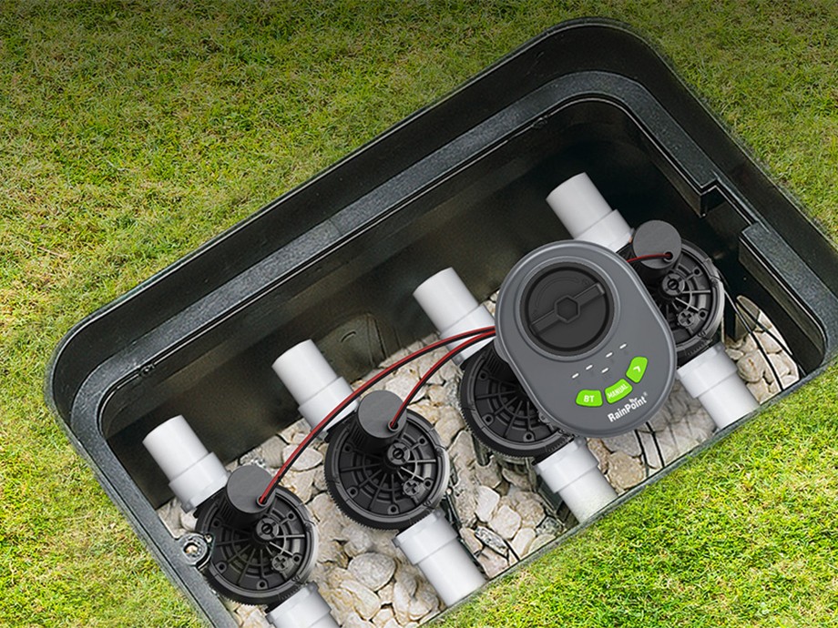 RainPoint controller installed in a box with four valves against a lawn background.