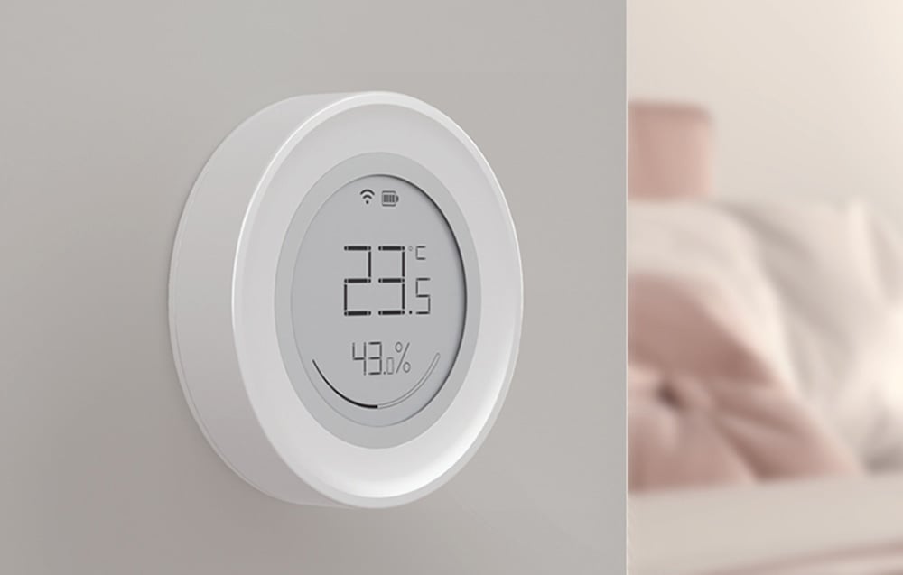 Sensor mounted on a wall in a bedroom, showing temperature of 23.5°C and humidity of 43.0%