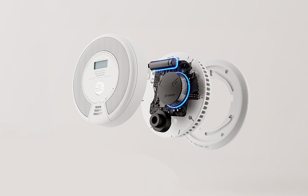 A technical cross-section of the disassembled carbon monoxide detector showing the housing, battery, and integrated circuit with backlighting