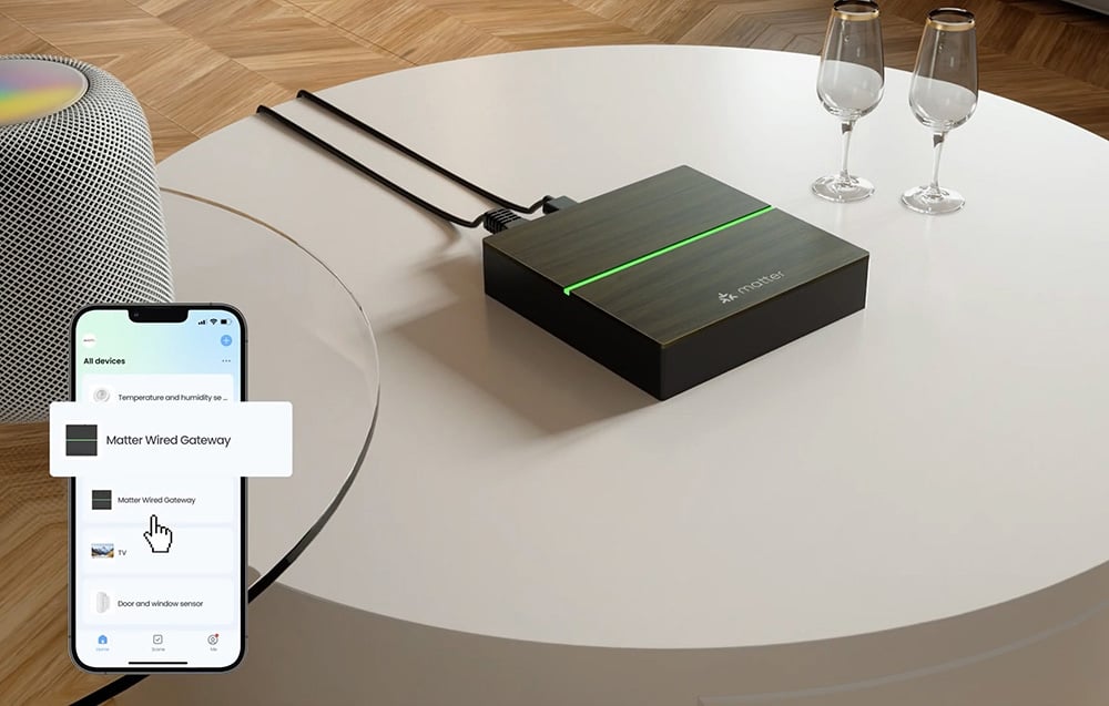 The Matter device on the round table with the connected cables visible, the two glasses and the smartphone showing the app interface with the Matter Wired Gatew