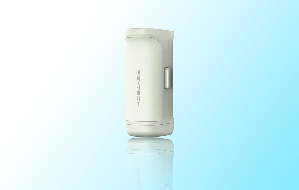 Light green cylindrical PGYTECH device with reflections on a glossy surface on a light blue background