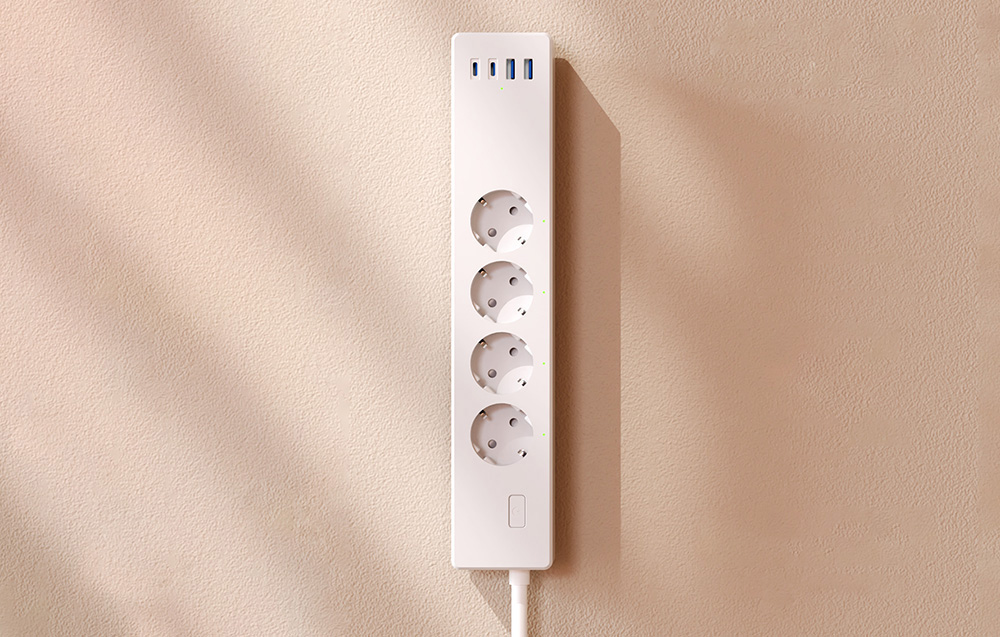 Top view of an empty power strip with four outlets and five USB ports, mounted on the wall